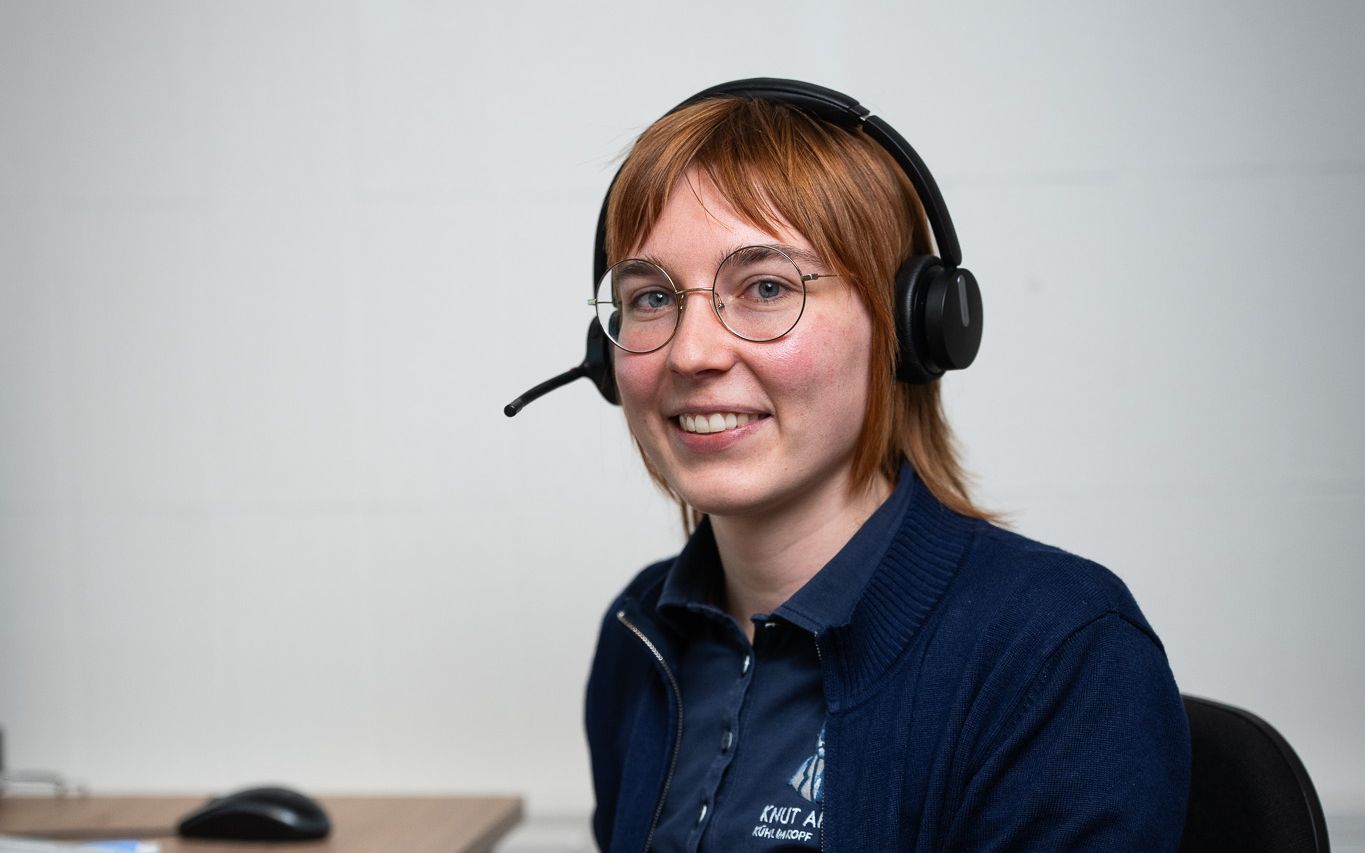 Mitarbeiterin mit Headset im Büro der Knut-Apotheke